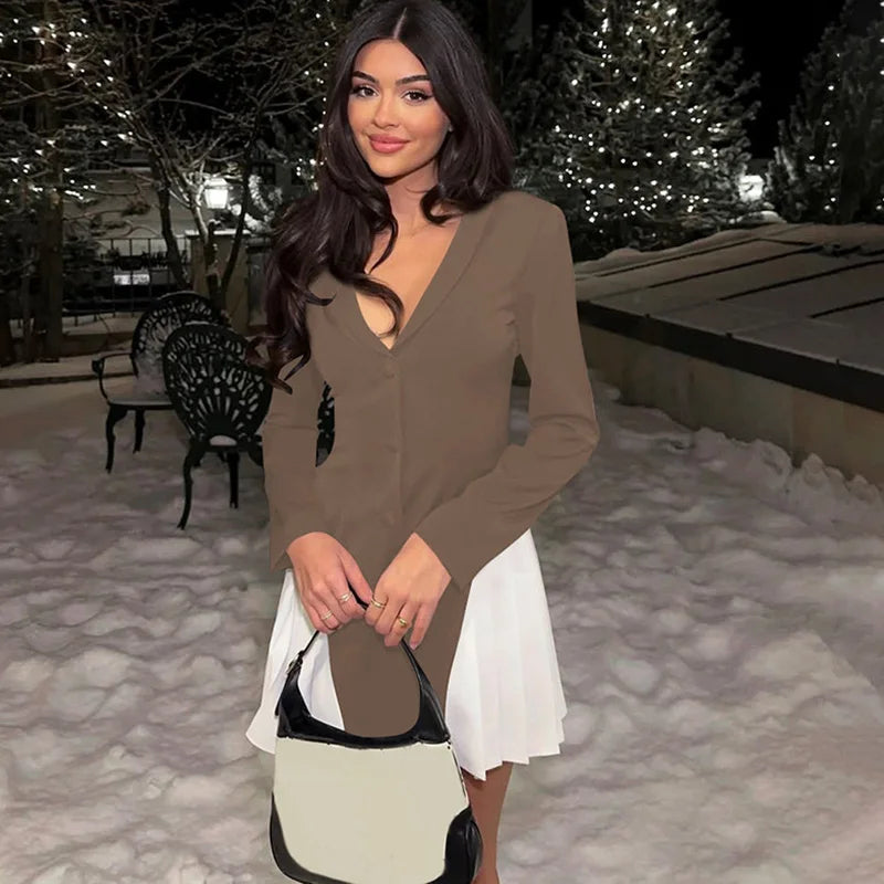 Woman in a brown dress with a white underskirt holding a handbag in a snowy outdoor setting.