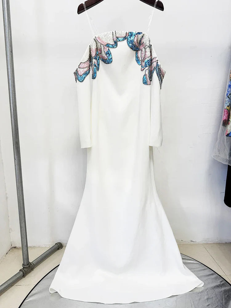 White dress with floral embroidery on a hanger against a white background