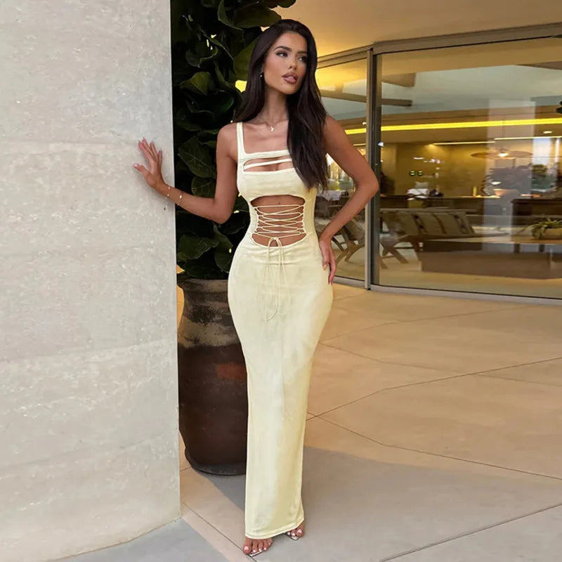 Woman in a stylish dress standing in an indoor setting with a modern interior.