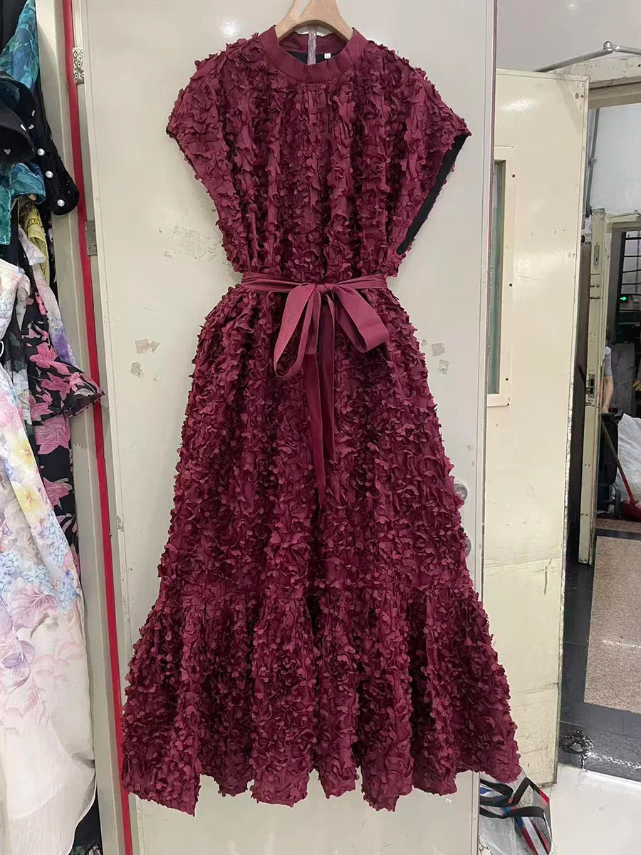 Maroon textured dress on a hanger against a neutral background