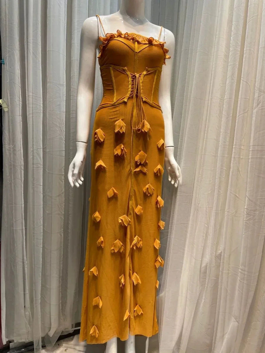 Mustard yellow dress with floral details on a mannequin against a white curtain background