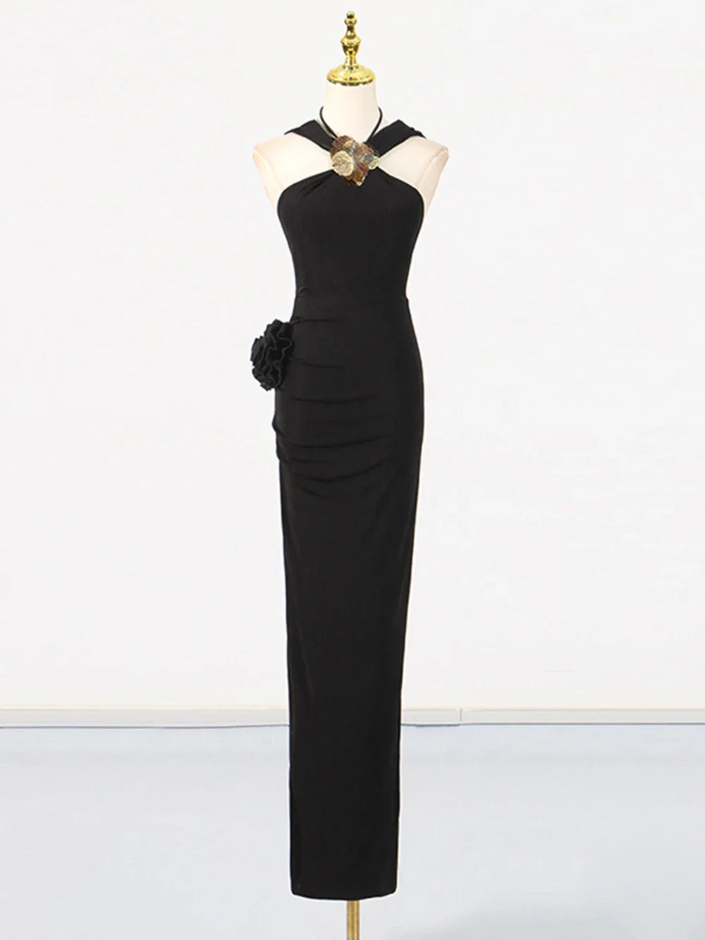 Black evening gown on a mannequin against a white background