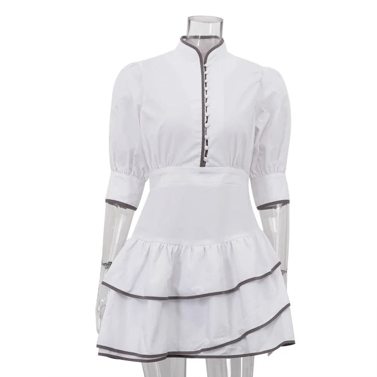 White dress with black trim on a mannequin against a white background