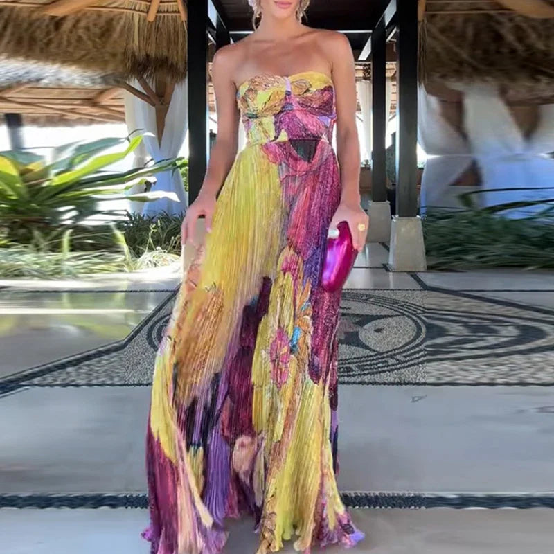 Woman in a colorful strapless dress holding a clutch in an outdoor setting.