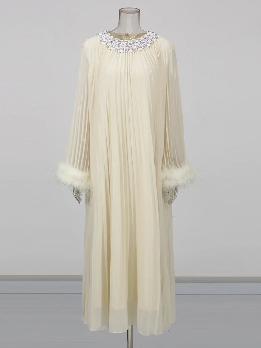 Cream-colored dress with feathered cuffs on a mannequin against a gray background