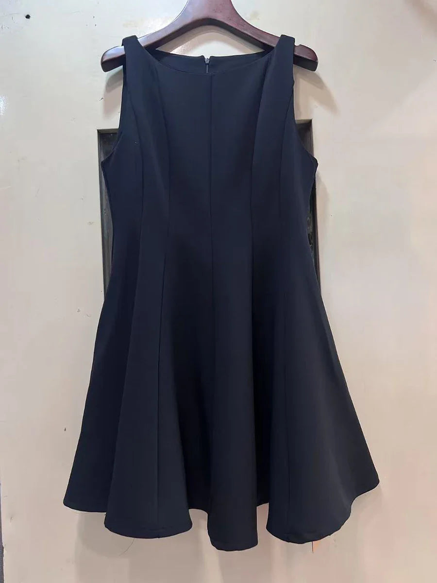 Navy blue dress on a hanger against a white wall