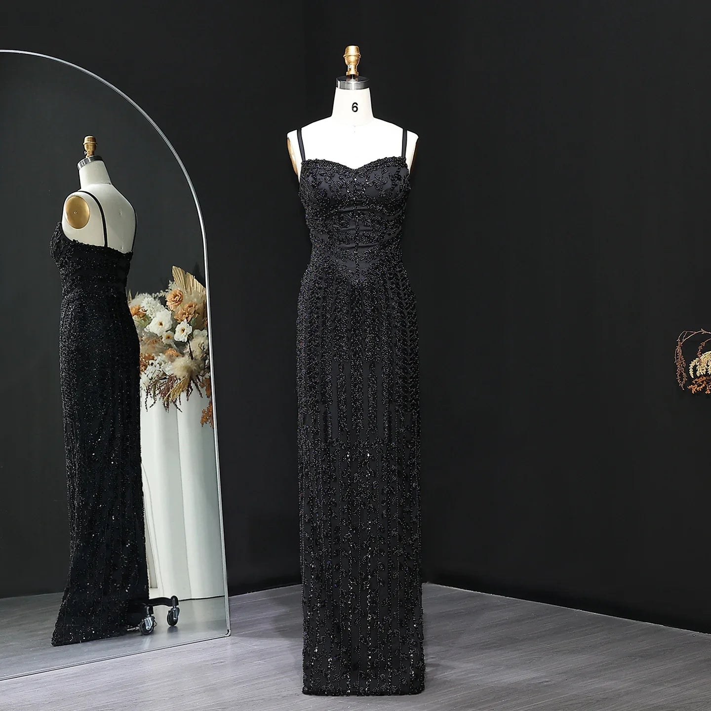 Black evening gown on a mannequin against a dark background