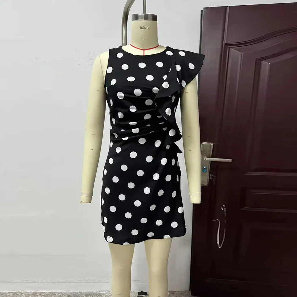Black dress with white polka dots on a mannequin against a door background