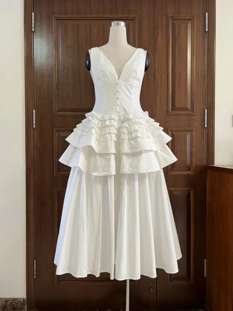 White ruffled dress on a mannequin against a wooden door.