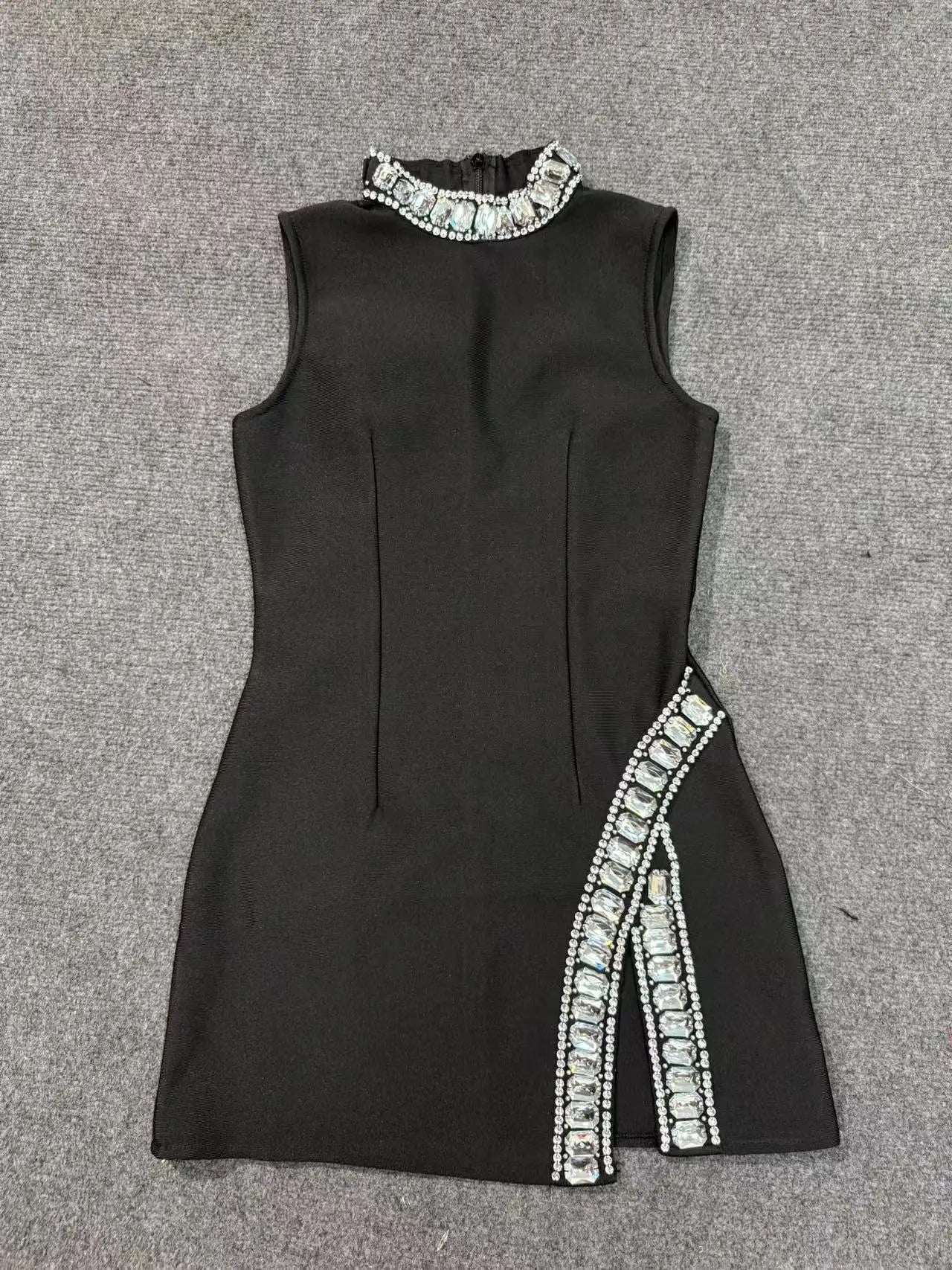 Black sleeveless dress with white embellishments on a gray background
