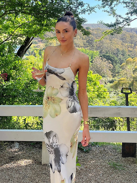 Woman in a floral dress standing outdoors with greenery in the background
