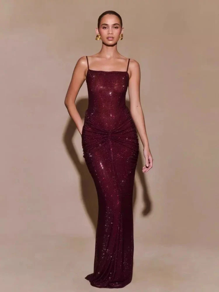 Woman wearing a burgundy evening gown with a plain background