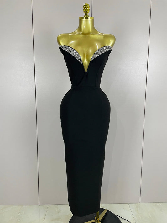 Black evening gown with beaded neckline on a mannequin against a plain background