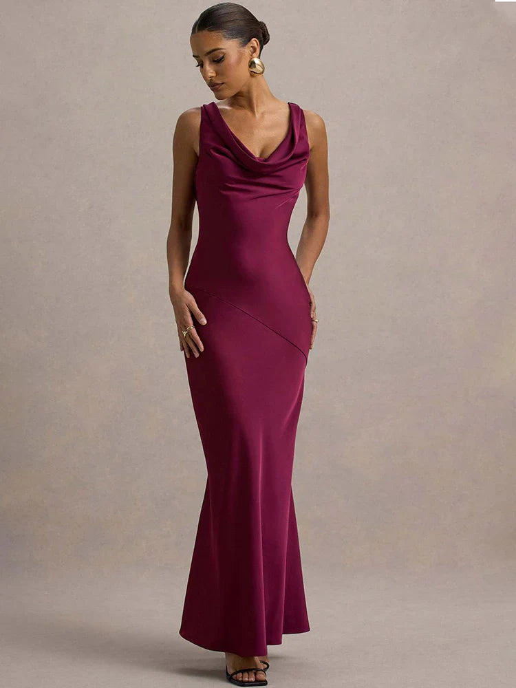 Woman wearing a burgundy evening gown against a neutral background