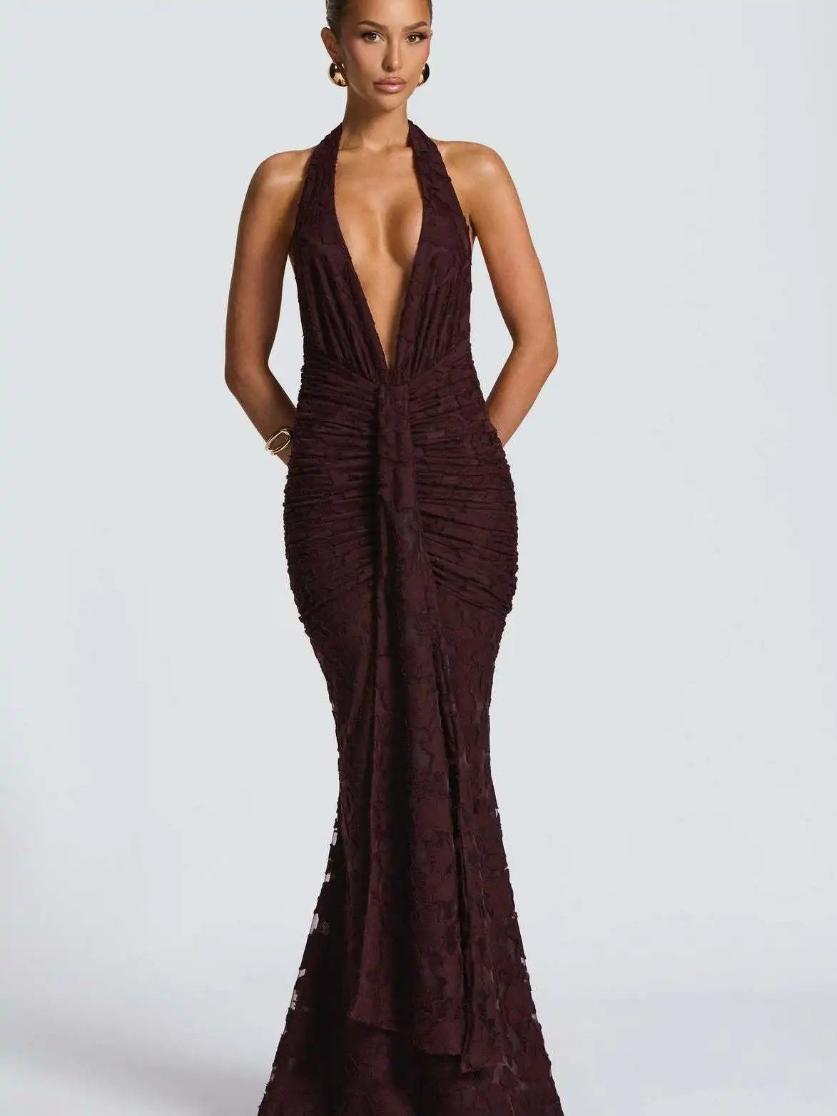 Woman wearing a deep-neck burgundy evening gown on a white background