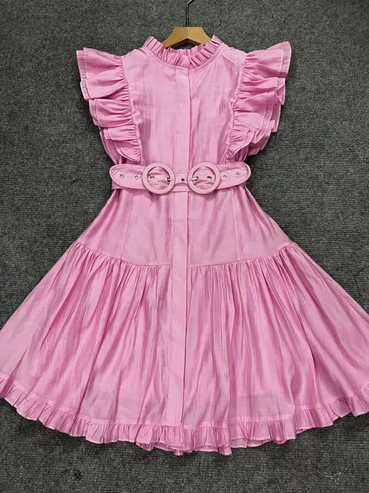 Pink dress with ruffled sleeves and waistband on a gray background