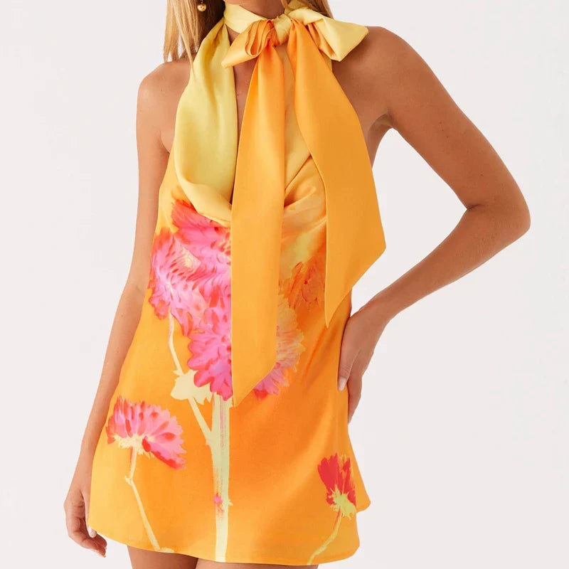Woman wearing a yellow floral dress with a plain background
