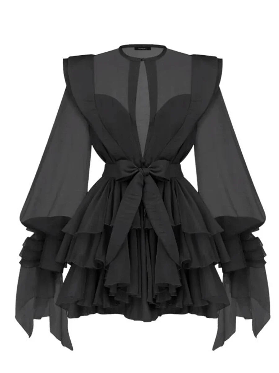 Black dress with ruffled layers and sheer sleeves on a white background