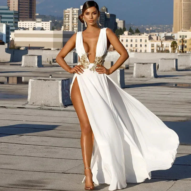 Woman in a white gown with gold accents on a rooftop with cityscape background