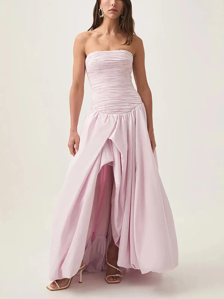 Woman wearing a strapless pink gown on a white background