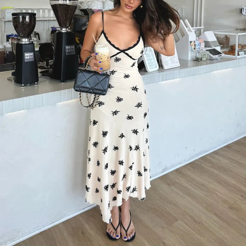 Woman in a white dress with black patterns standing in a coffee shop.