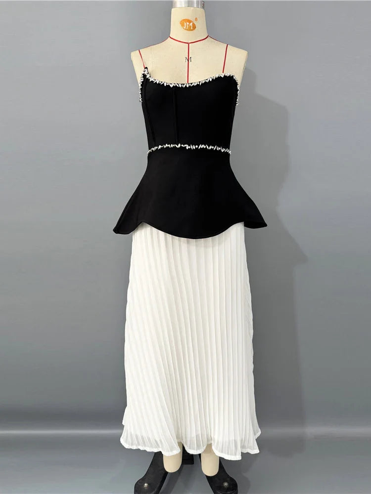Black top and white pleated skirt on a mannequin against a gray background