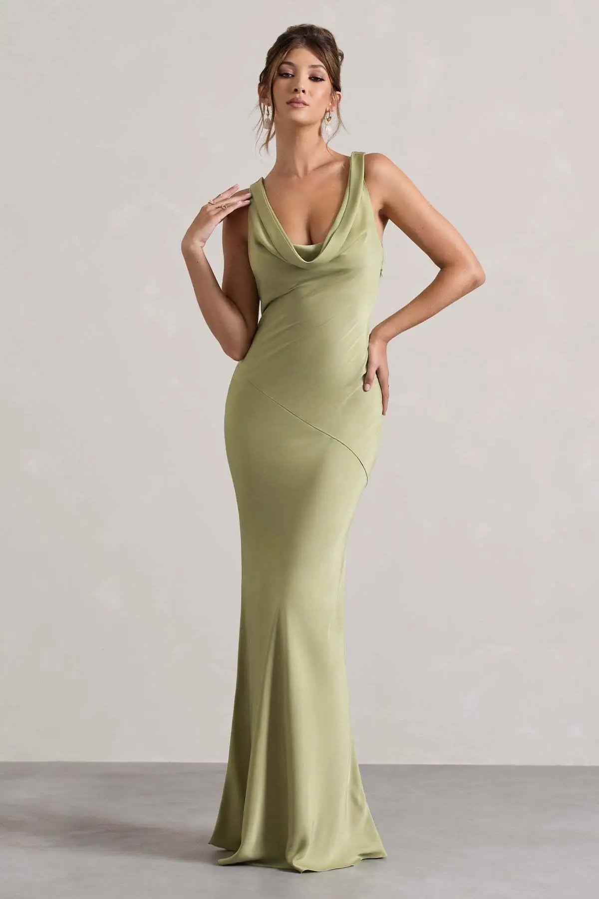 Woman wearing a green evening gown against a plain background