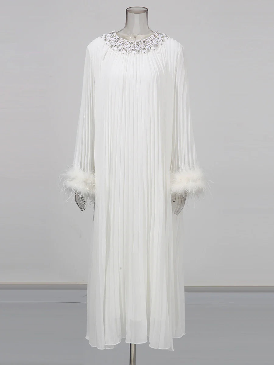 White dress with embellishments on a mannequin against a gray background