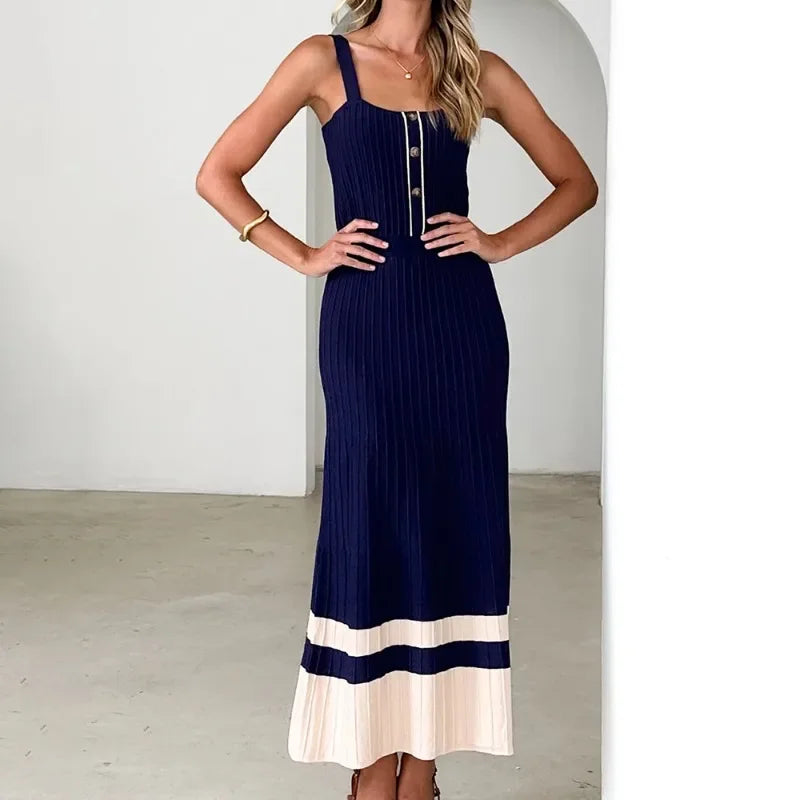 Woman wearing a navy dress with a white hem in a minimal indoor setting