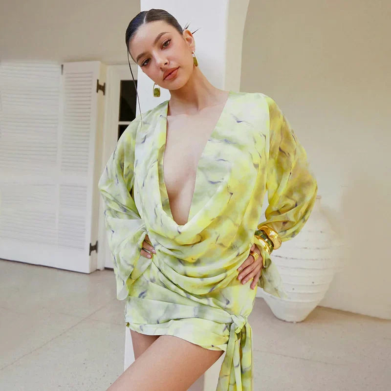 Woman wearing a light green dress with a plunging neckline in an indoor setting.