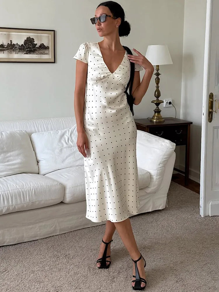 A woman wearing an elegant floral printed satin dress with a V-neckline.