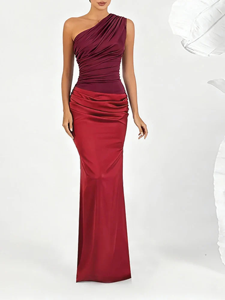 Woman wearing red one shoulder satin drape maxi dress