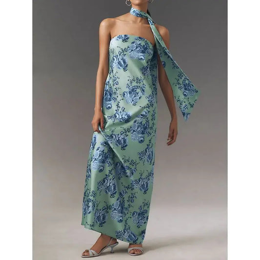Woman wearing a strapless floral satin dress styled for summer evenings with a matching scarf on a neutral background