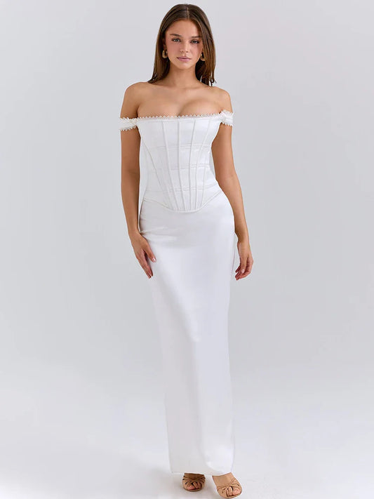 Woman wearing a white satin off-shoulder gown with a backless design on a white background